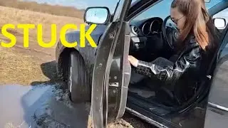 Women with black car stuck in mud