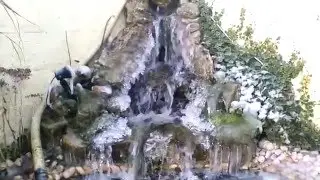 Bassin de jardin avec cascade gelee par le froid