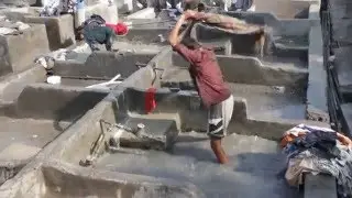 Man, washing clothes at the river Gang in India