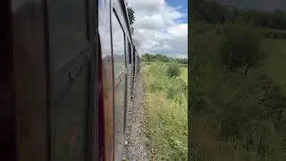 On-board Mark 1 coach lead by steam locomotive