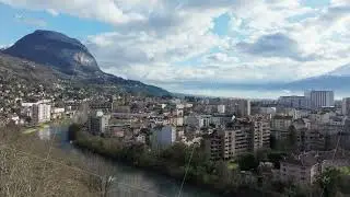 Aerial view of Grenoble city center, showcasing the Isere river winding through buildings and the