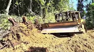 Powerful Bulldozer Carving a Road Through a Steep Red-Soil Mountain Cliff Edge