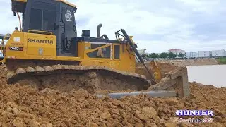 Dump truck unloading soil mix Rock, Mighty strong Dozer SHANTui use the power pushing clearing land
