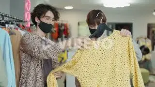 Stylist in Face Mask Helping Female Customer in Clothes Shop
