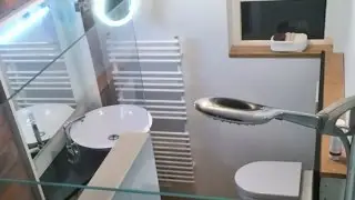 Minimalistisches Bad mit Glasr&uuml;ckwand statt Fliesen &ndash; modernes Design auf kleinem Raum