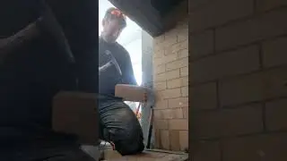 cutting a fire brick with a brick hammer