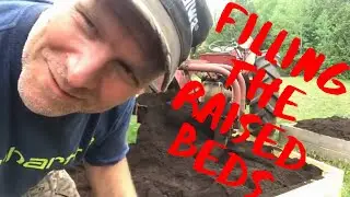 Filling the raised beds with topsoil using the Massey and the dirt scoop. Victory Garden Series