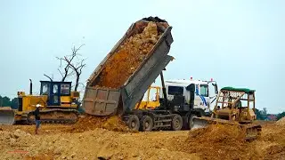 Extremely operating bulldozer job pushing concurrent with dumper truck spread soils