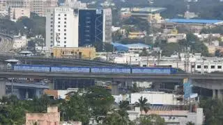 Chennai Metro Train wrapped with advertisement crosses Kathipara
