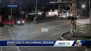Wild video shows driver go airborne over train tracks in front of cop