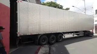 carreta manobrando em rua estreita.