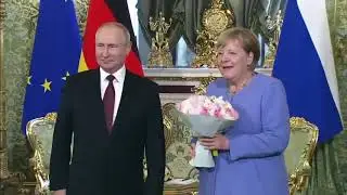 Russian President Vladimir Putin brought flowers for German Chancellor Angela Merkel