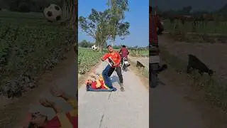 Мальчик играет в футбол посреди дороги.