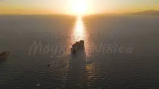 Kusadasi, Turkey. Virgin Voyages Resilient Lady sails into sunset on golden water pathway. Aerial...