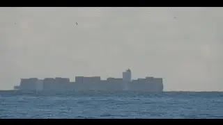 Container ship, bottom part beyond the horizon