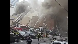 Baltimore City Fire officials battle a 5 alarm building fire Sunday morning on Lombard Street