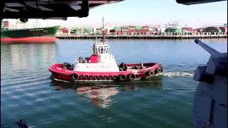 Crowley Tugboat Master slides by Battleship Iowa