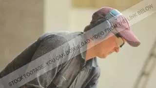 Man working with a chainsaw. Wood shavings are flying saw his face. Close up