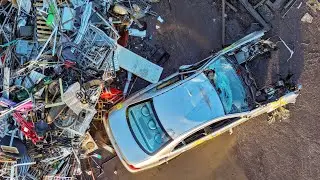 Drone View of Scrapyard: Powerful Machine Lifts Cars & Scrap Metal into a Pre-Shredder