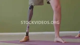 man with prosthetic leg doing yoga with...