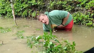 Unclogging a rural culvert.