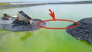 Wow! Amazing dump trucks cooperate with Bulldozer pushing stone into the big lake