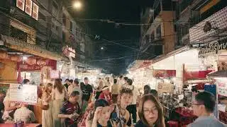 Crowded street in Chinatown at night in Bangkok, Thailand. People walking among food stalls