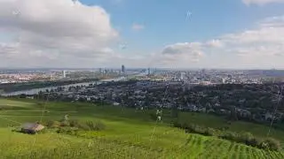 Aerial views showcase Vienna's skyline, featuring the Danube River and lush vineyards in the