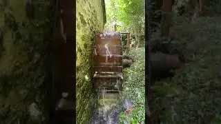 Water mill Ireland. Water running over working mill wheel