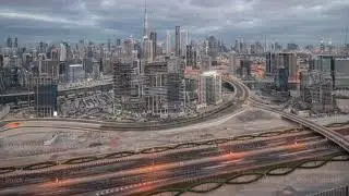 Panoramic skyline of Dubai with business bay and downtown district night to day timelapse.