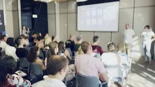 Business conference attendees listening to a presentation with projector screen
