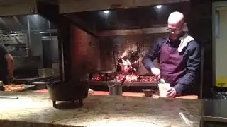 Metropole Chef Jared Bennett puts food in fireplace oven
