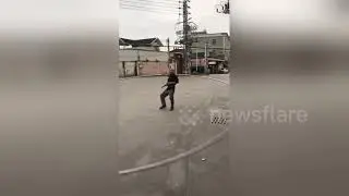 Chinese man exercises with giant metal hula-hoop