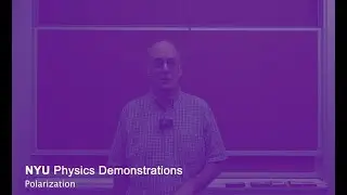 Professor Allen Mincer explains polarized light before hiding behind multiple polarizing sheets.