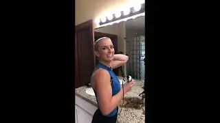 Sexy blonde woman buzzing her hair off in the bathroom