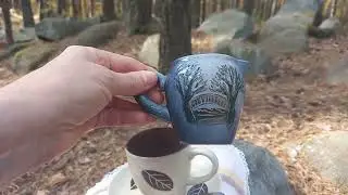 Чашка кофе в мини-самоваре в осеннем лесу.