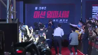 Tom Cruise makes a heart-shaped gesture as he poses with the cast of 