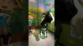 Milk? Cute Baby David is playing with a big cow