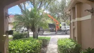 Grapple Truck picking up old platform bed