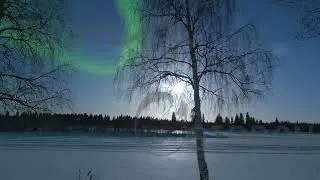 Winter Moonrise Timelapse Over Frozen River with Aurora in Arctic Lapland