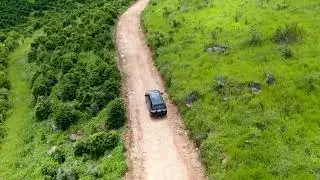 Aerial view of a car driving on small dirt road in tropical valley. Brazil in 4k | Free Stock Video