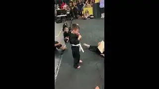 Children in Karate Class Cheer Kid on While Kicking Board - 1042142