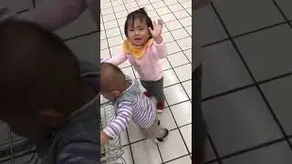 Twins fighting for a shopping cart