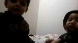 Baby girl is trying to kiss her angry brother
