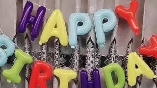 Rainbow-colored happy birthday balloons