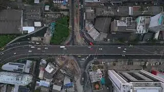 Aerial view from above of busy urban traffic driving on highway overpass and intersecting roads in