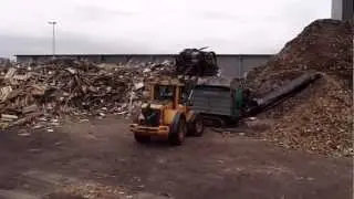 G.M. Damsteegt met een Crambo 6000 sloophout aan het verkleinen