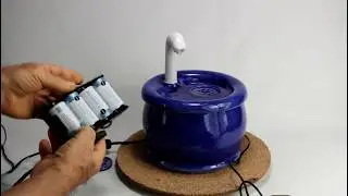 A handcrafted ceramic cat drinking fountain with faucet spout