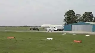 Light plane taxiing and hangars at Kemble Cotswold Airport Cirencester