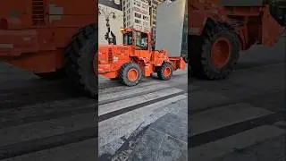 Фронтальный погрузчик DSNY проезжает по 8-й авеню в центре Манхэттена, Нью-Йорк.